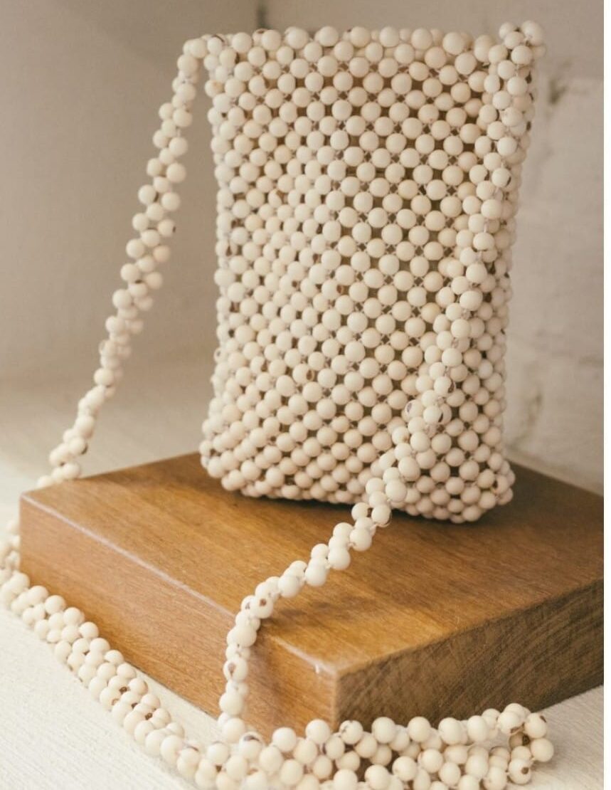 Imagem colorida mostra bolsa feita de sementes, da Artesã Márcia Silvia